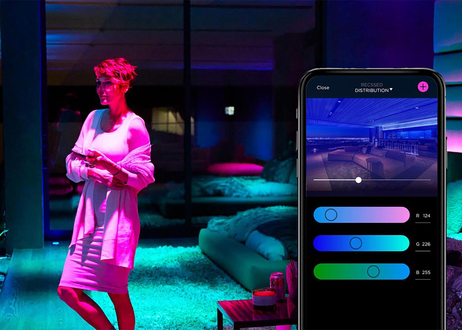 Woman using smartphone to adjust colorful smart lighting in a modern room