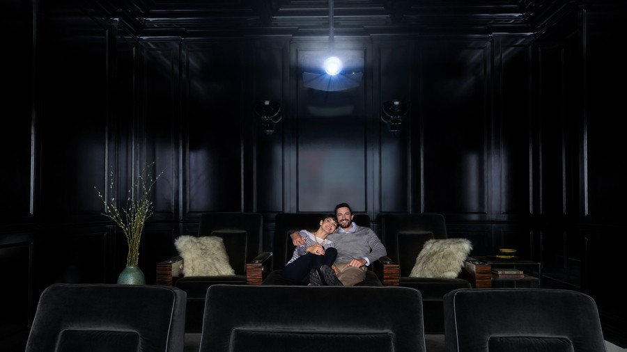 A couple enjoys a film in a professionally designed high-end home theater in Colorado.