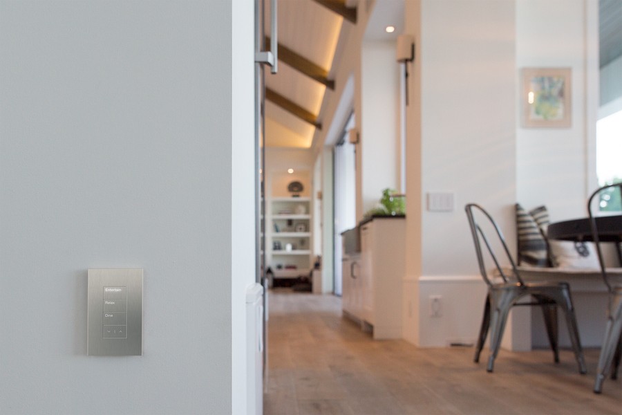  A view of a Lutron Palladiom keypad on the wall of a Colorado living area with Lutron motorized shades. 