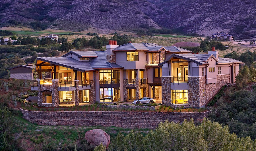 A sprawling smart home in Colorado Springs with interiors illuminated at dusk. 